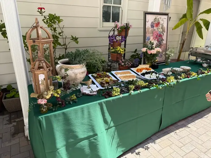 Grazing station of seasonal appetizers, cheeses, and fresh fruit with botanical styling at a private party catered in Daly City